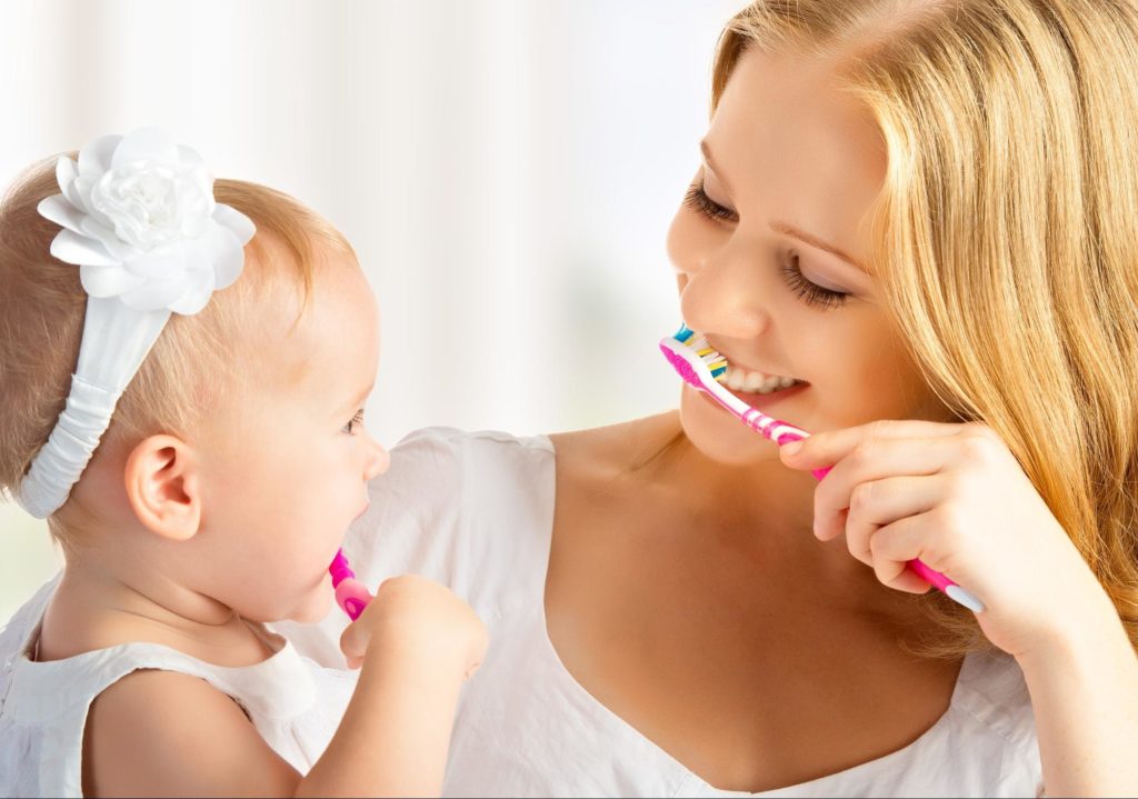 mother and daughter brushing their teeth