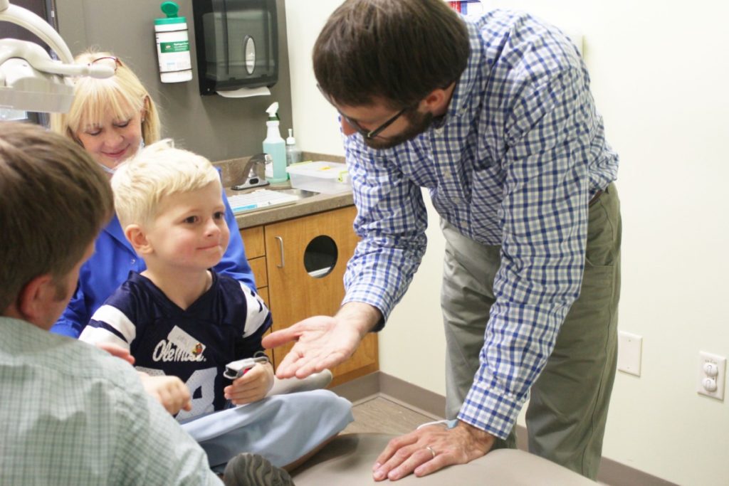 Dentist at Children's Dental center giving a high five to a child patient