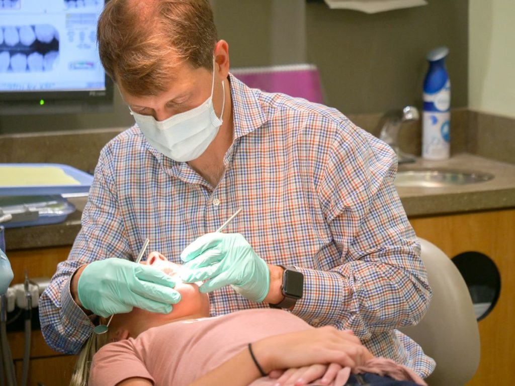 Doctor working on girl's teeth