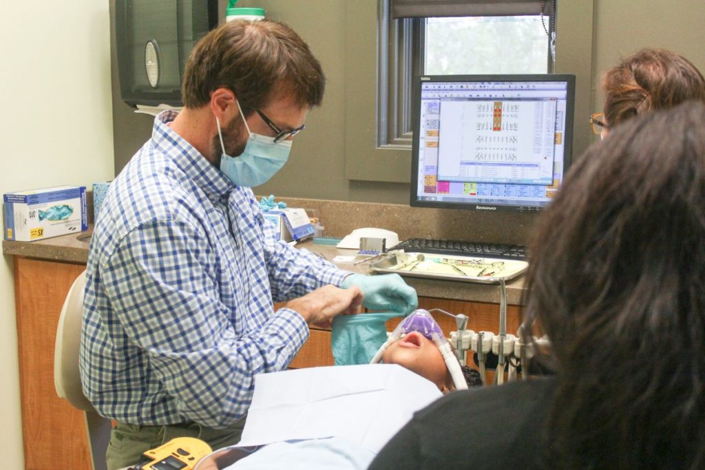 Doctor cleaning young boys teeth