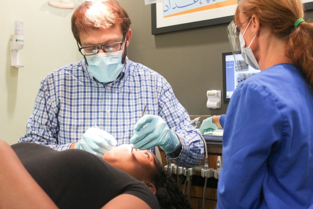 Dr. working on a young patient's teeth