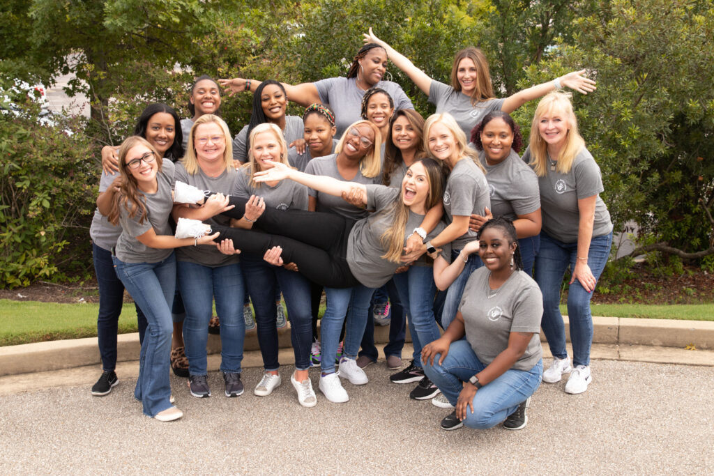 Children's Dental Center team posing joyfully outdoors, showcasing camaraderie and dedication to pediatric dental health.